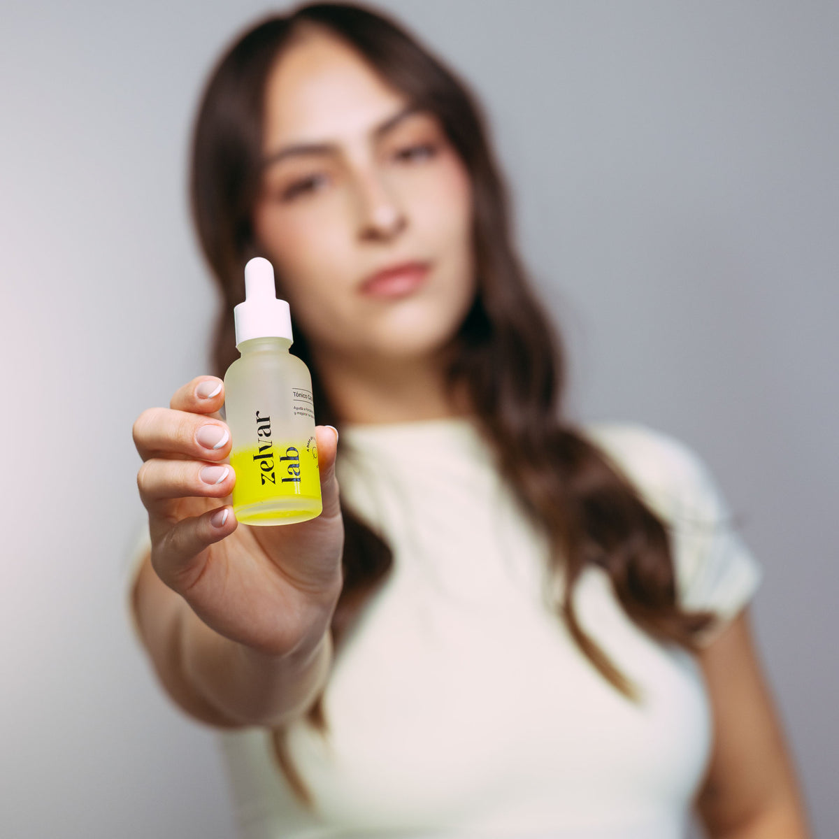 Mujer mostrando el tónico capilar Zelvar Lab del kit de 90 días